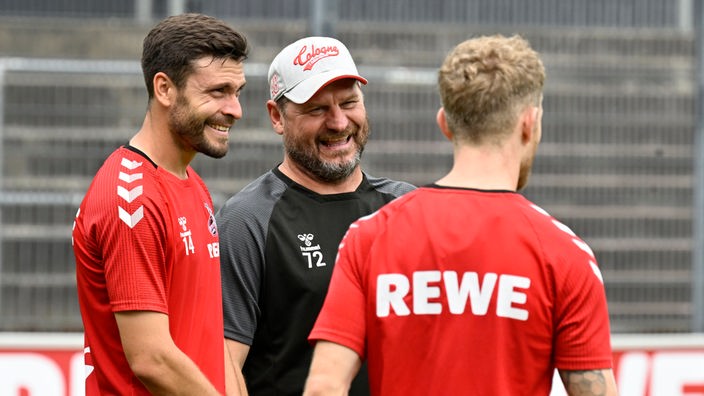 Trainer des 1.FC Köln, spricht mit seinen Spielern Jonas Hector (l) und Florian Kainz