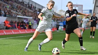 Kathrin Hendrich (VfL Wolfsburg, l.) im Duell mit der Essenerin Paula Flach