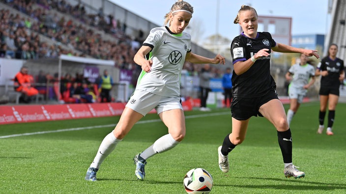 Kathrin Hendrich (VfL Wolfsburg, l.) im Duell mit der Essenerin Paula Flach