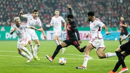 Leverkusens Nathan Tella behauptet sich gegen drei Düsseldorfer Spieler im Halbfinale des DFB-Pokals
