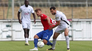 Kamer Krasniqi (r.) von den Sportfreunden Lotte und Ben Klefisch vom KFC Uerdingen im Zweikampf um den Ball