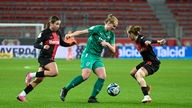 Annalena Rieke (SGS Essen) setzt sich gegen Spielerinnen von Bayer 04 Leverkusen durch