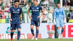 Nach dem Spiel bei Werder Bremen laufen die Bochumer Takuma Asano (l.), Cristian Gamboa (M.) und Manuel Riemann enttäuscht über den Platz