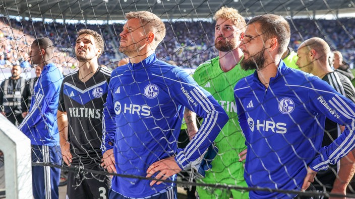 Schalker Spieler stellen sich nach ihrem desolaten Auftritt beim KSC den wütenden Fans.