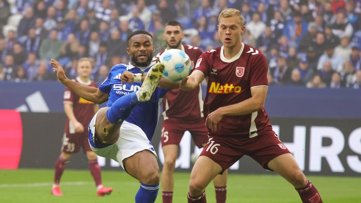 Schalkes Moussa Sylla im Zweikampf mit Louis Breunig von Jahn Regensburg