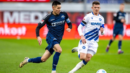 Paderborns Raphael Obermair (l) und Karlsruhes Marvin Wanitzek kämpfen um den Ball