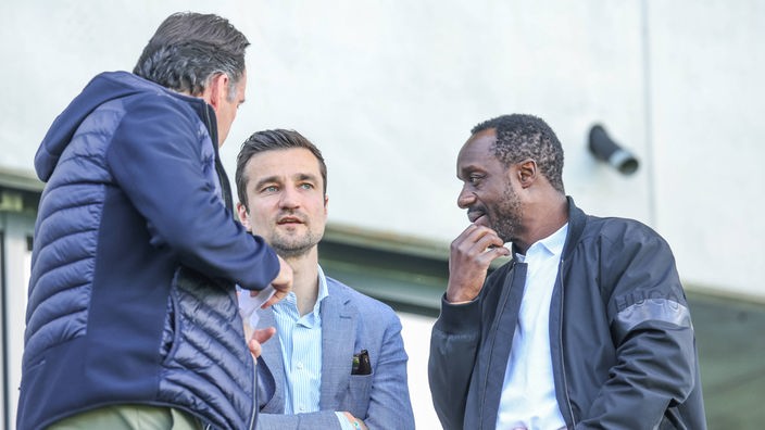 Schalkes Sportdirektor Marc Wilmots (v. l.), Vorstandsvorsitzender Matthias Tillmann und Kaderplaner Ben Manga im Gespräch.