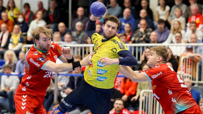 Malte Seidel und Alexander Schoss (TuSEM Essen) versuchen, Olle Forsell Schefvert von den Rhein-Neckar Löwen zu stoppen.