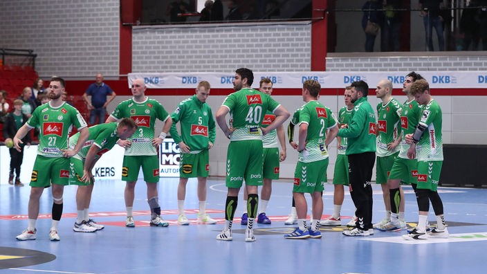 Die Spieler der GWD Mindne blicken zu Boden, sie sind aus der ersten Handball-Bundesliga abgestiegen