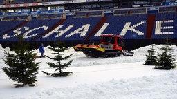 Eine Schneeraupe prepariert die Stadionfläche auf Schalke