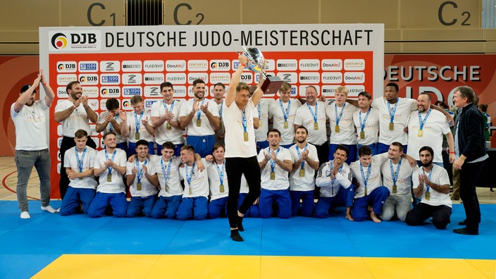 Manager Cedric Pick mit Pokal und Mannschaft.