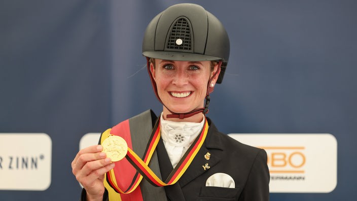 Jessica von Bredow-Werndel hält ihre Goldmedaille nach dem Gewinn des Grand Prix Special