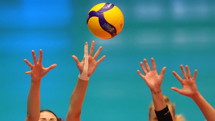Spielszene beim Volleyball: Vier Hände beim Block
