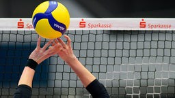 Ein Volleyball wird über ein Volleyball-Netz gepritscht