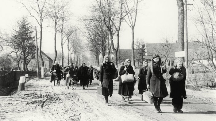Eine Gruppe Vertriebener zieht durch das Dorf Grochow