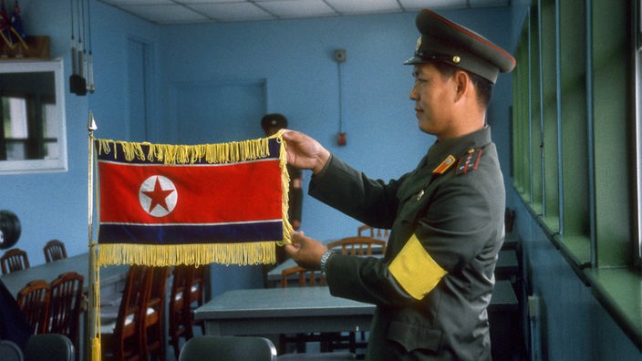 Ein Soldat präsentiert die nordkoreanische Fahne