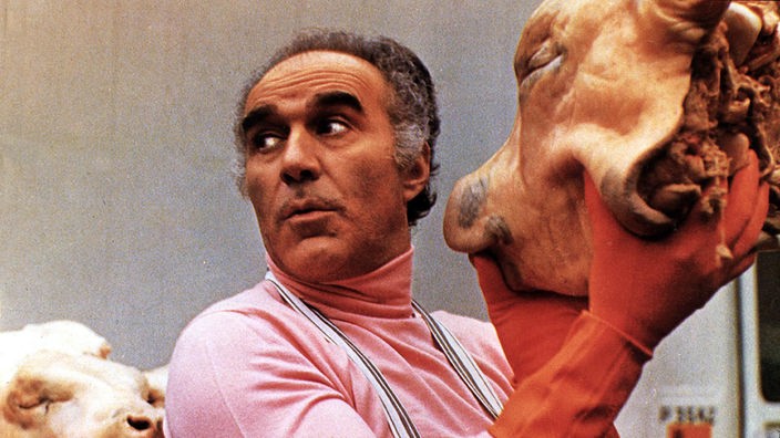 Michel Piccoli hält Schweinekopf hoch/Szenenfoto aus "Das große Fressen"