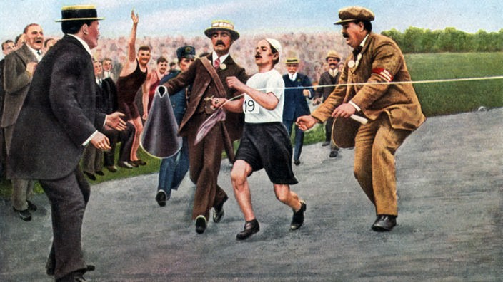 Dorando Pietri mit Helfern im Ziel des Marathonlaufs der Olympischen Spiele London 1908  
