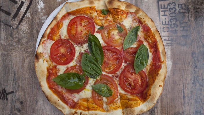 Pizza Margherita belegt mit Tomate, Basilikum und Mozzarella