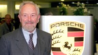  Ferdinand Alexander Porsche, Aufsichtsratsmitglied des Stuttgarter Sportwagenherstellers Porsche, stehtin Stuttgart vor der Hauptversammlung vor einem Firmenlogo