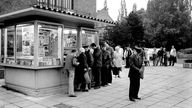 Kunden stehen an einem Zeitungskiosk in Rostock (Aufnahme von 1985)