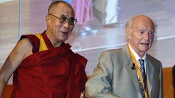 Der 14. Dalai Lama (l.) fuehrt am Donnerstag (28.07.05) zum Ende der Festveranstaltung "Freunde fuer einen Freund" im Kurhaus von Wiesbaden seinen aeltesten Freund, den oesterreichischen Bergsteiger Heinrich Harrer, von der Buehne. 