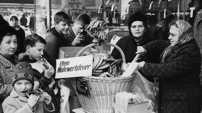 Eine Verkäuferin verkauft am 03.01.1968 Brezel nach der Einführung der Mehrwertsteuer zum alter Preis 
