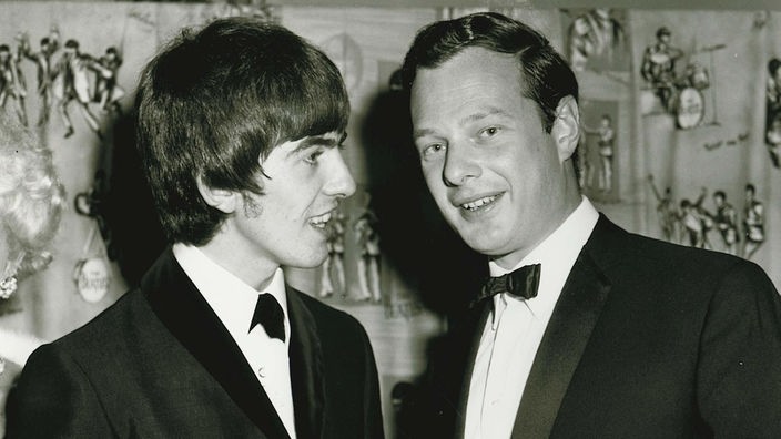 George Harrison und Brian Epstein bei einer Filmpremiere am 06.01.1964