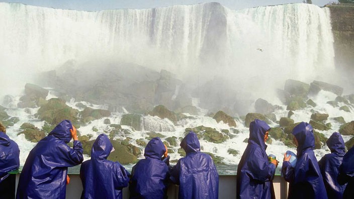 Touristen mit Regenmänteln an den Niagara-Wasserfällen in Ontario, Kanada 