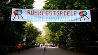 Zwischen Bäumen aufgehängtes Werbebanner für die Ruhrfestspiele 