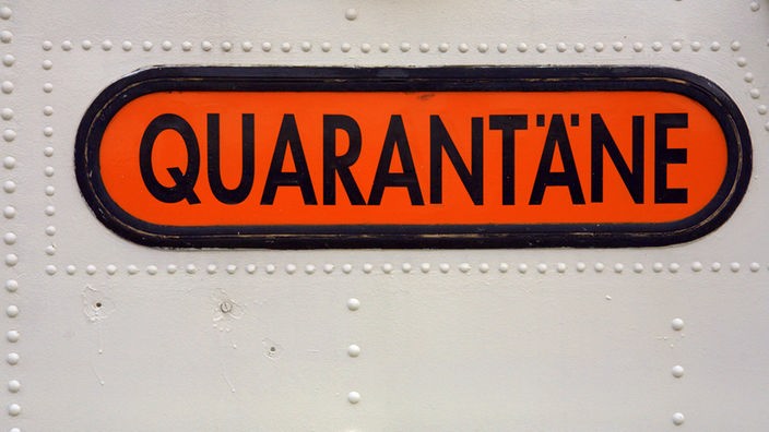 Schild mit der Aufschrift 'Quarantäne' auf einer Tür