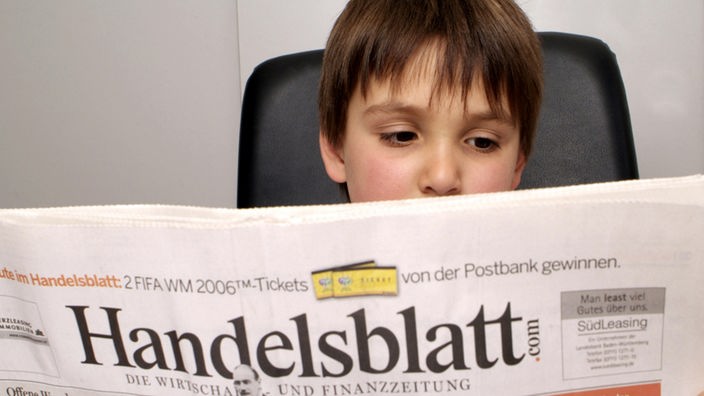 Ein Kind liest das Handelsblatt