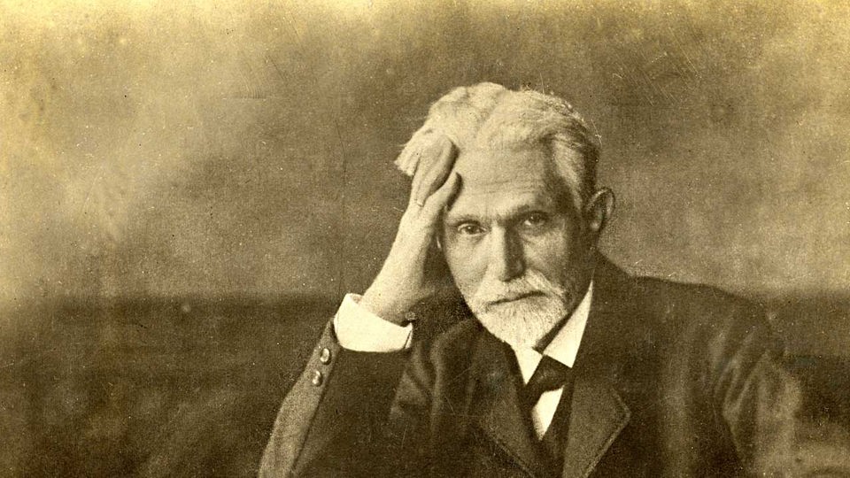 August Bebel sitzend, Kopf in Hand gestützt (Sepia-Foto, um 1910)