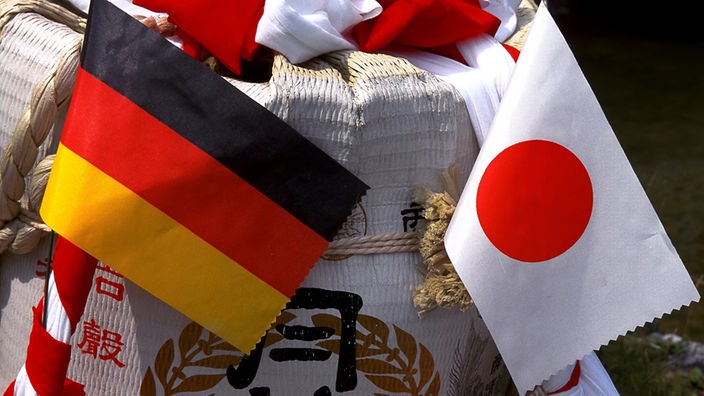 Deutsche und japanische Flagge als Fähnchen hinten an japanischem Kostüm befestigt 