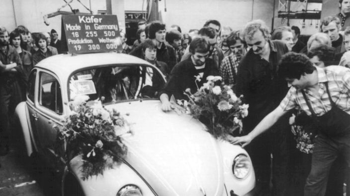 Arbeiter im Emder VW-Werk verabschieden den letzten blumengeschmückten Käfer