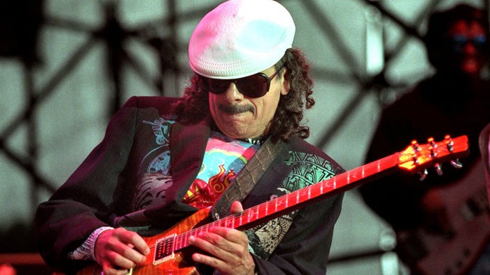 Carlos Santana mit weißer Kappe und Gitarre bei Live-Konzert (2009)