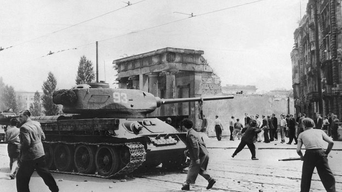 Demonstranten werfen am 17.06.1953 in Berlin mit Steinen nach russischen Panzern 
