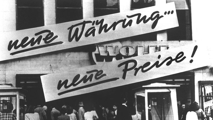 Kundenandrang vor einem Geschäft, das nach der Währungsreform am 20.06.1948 Schilder mit der Aufschrift "Neue Währung ... neue Preise!" angebracht hat