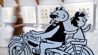 Eine Frau geht am 21.09.2012 durch die neue Ausstellung "Gezeichnetes Leben - Lebendige Zeichnung" des Zeichners Erich Ohser in der Galerie e.o.Plauen in Plauen.