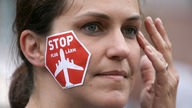 Eine junge Frau nimmt am 11.06.2012 an einer Demonstration gegen Fluglärm teil.