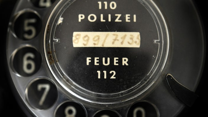 Telefon-Wählscheibe mit Aufschriften "110 Polizei" und "112 Feuerwehr"