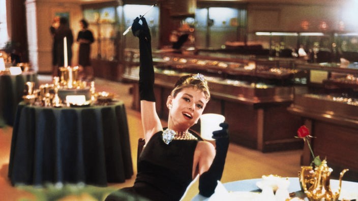 Audrey Hepburn als Holly  Golightly frühstückend bei Tiffany (Filmfoto)