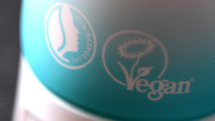 Das von der "Vegan Society England" vergebene Siegel Veganblume (r.) und das Nature-Siegel auf einer Handcreme-Verpackung