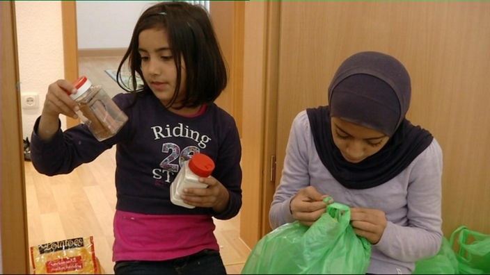 Tiba packt Lebensmittel mit ihrer Schwester aus