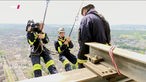 Feuerwehr und Kameramann seilen sich am Funkturm in Düsseldorf ab
