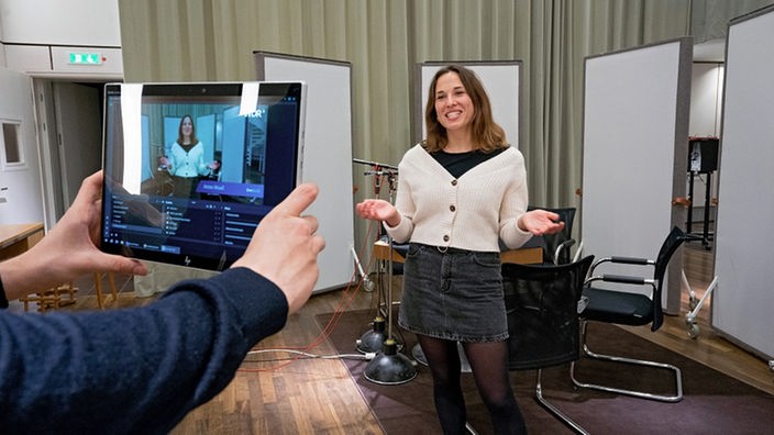 Besucherführerin wird im Audiostudio mittels Tabletcomputer gefilmt
