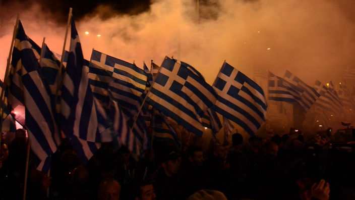 Mitglieder der “Goldenen Morgenröte” schwenken griechische Flaggen auf einer öffentlichen Versammlung der Partei.