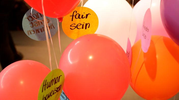 Bunte Luftballons und Schilder mit Sprüchen