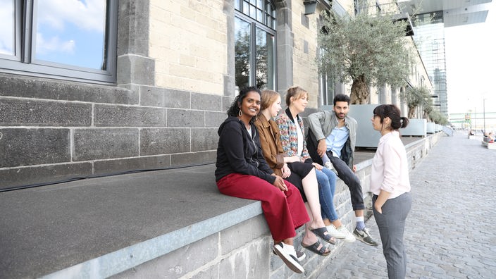 Junge Menschen sitzen am Rhein