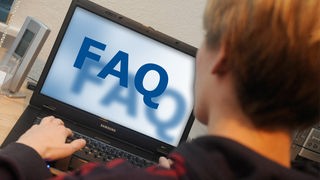 Jugendlicher surft mit Laptop, auf dessen Monitor FAQ zu lesen ist